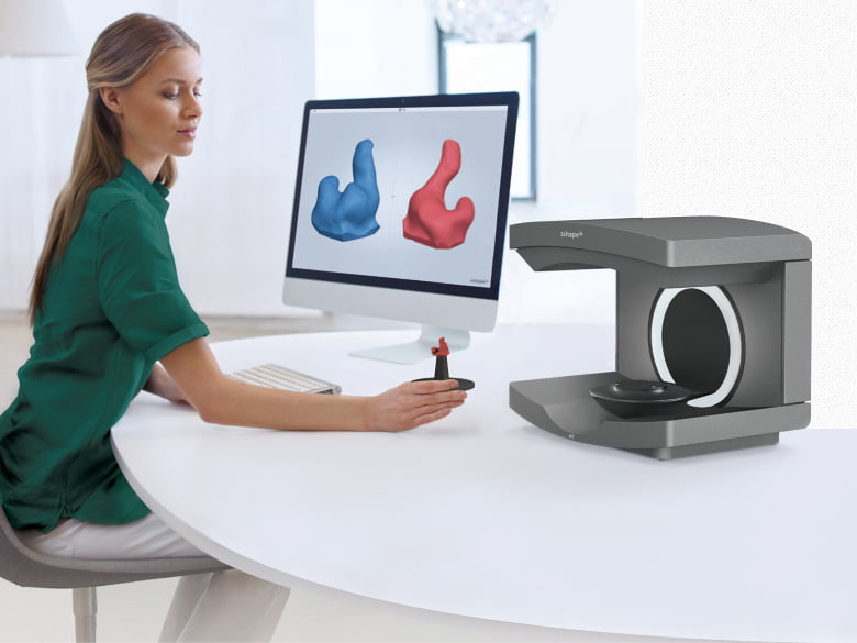 Девушка сканирует беруши на 3D-сканнере 3Shape A1